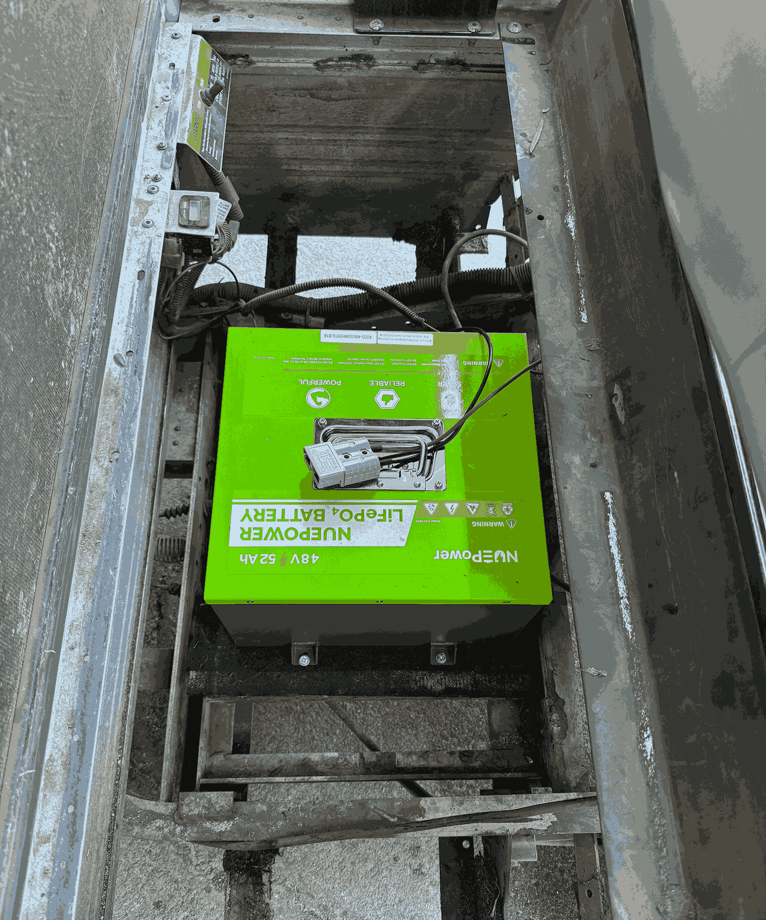 NUEPower 48V 52Ah battery installed in a compartment with visible wiring.